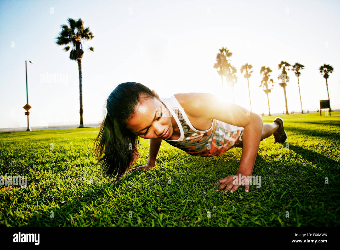 Mixed Race athlète faisant push-ups in park Banque D'Images