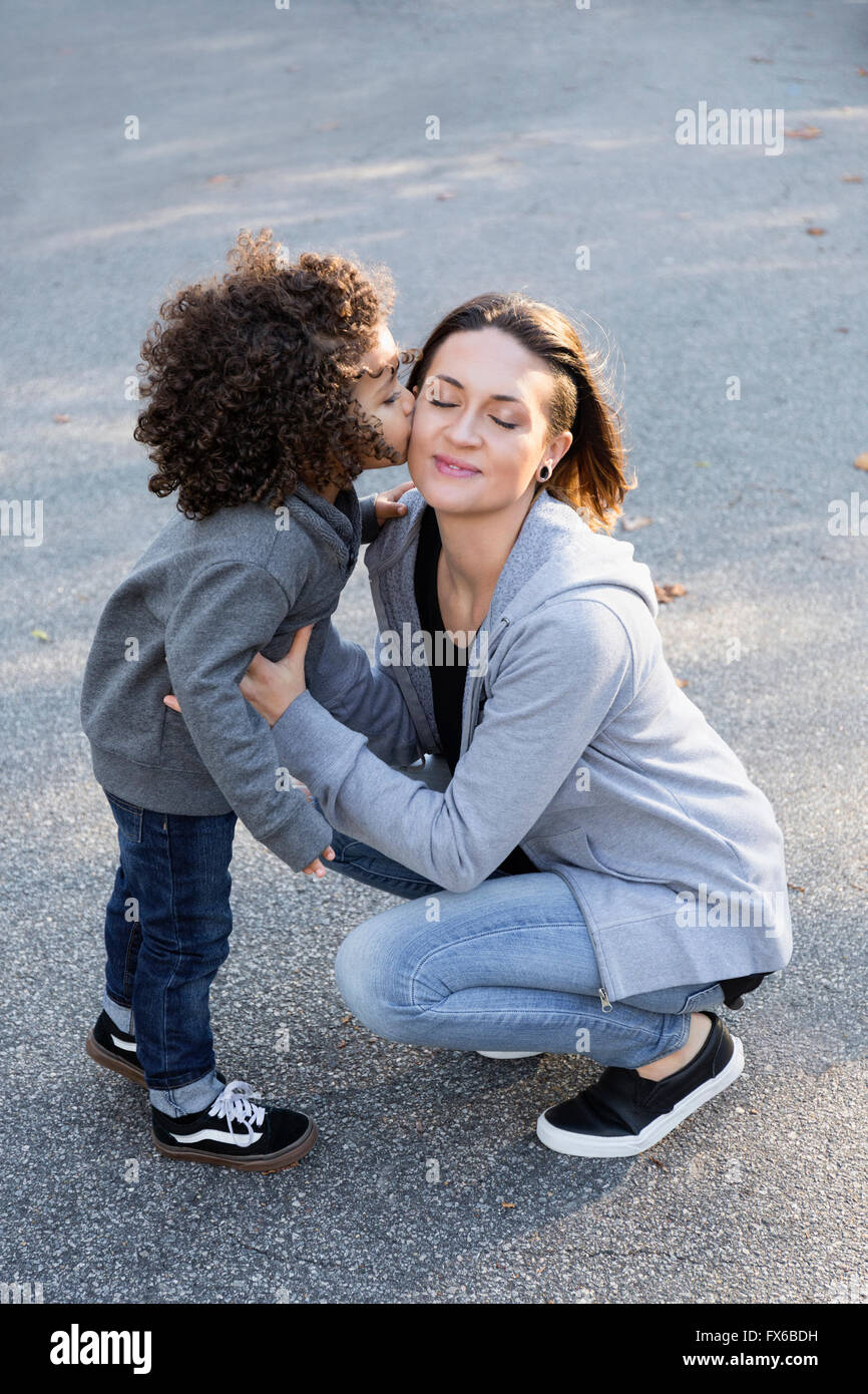 Boy kissing joue de la mère à l'extérieur Banque D'Images
