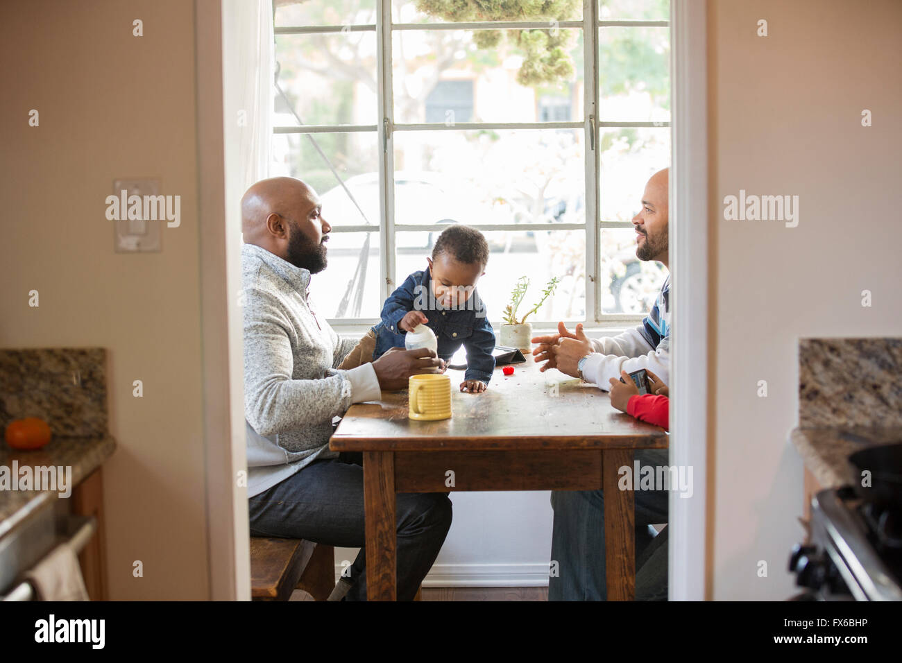 Les pères et les enfants assis à table Banque D'Images