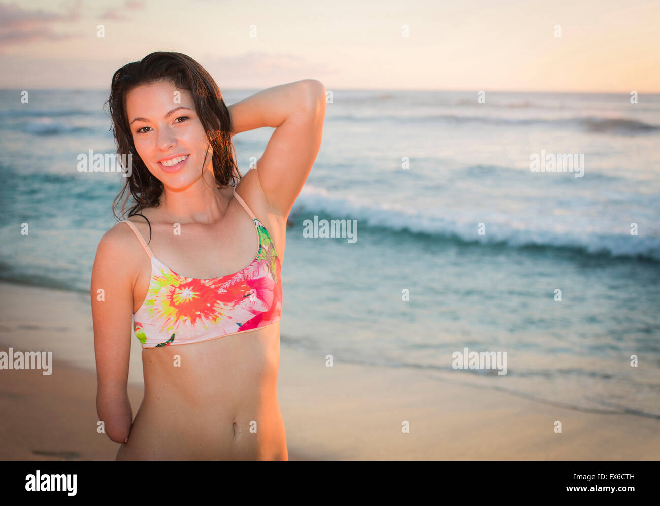 Mixed Race amputee smiling on beach Banque D'Images