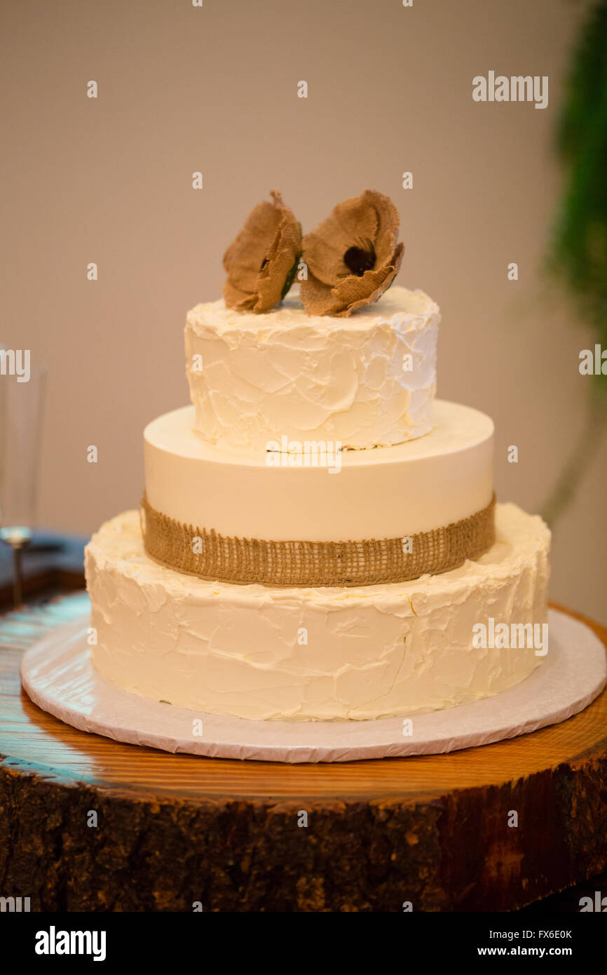 Ronde en bois tenant un gâteau de mariage pour la mariée et le marié à couper à leur réception. Banque D'Images
