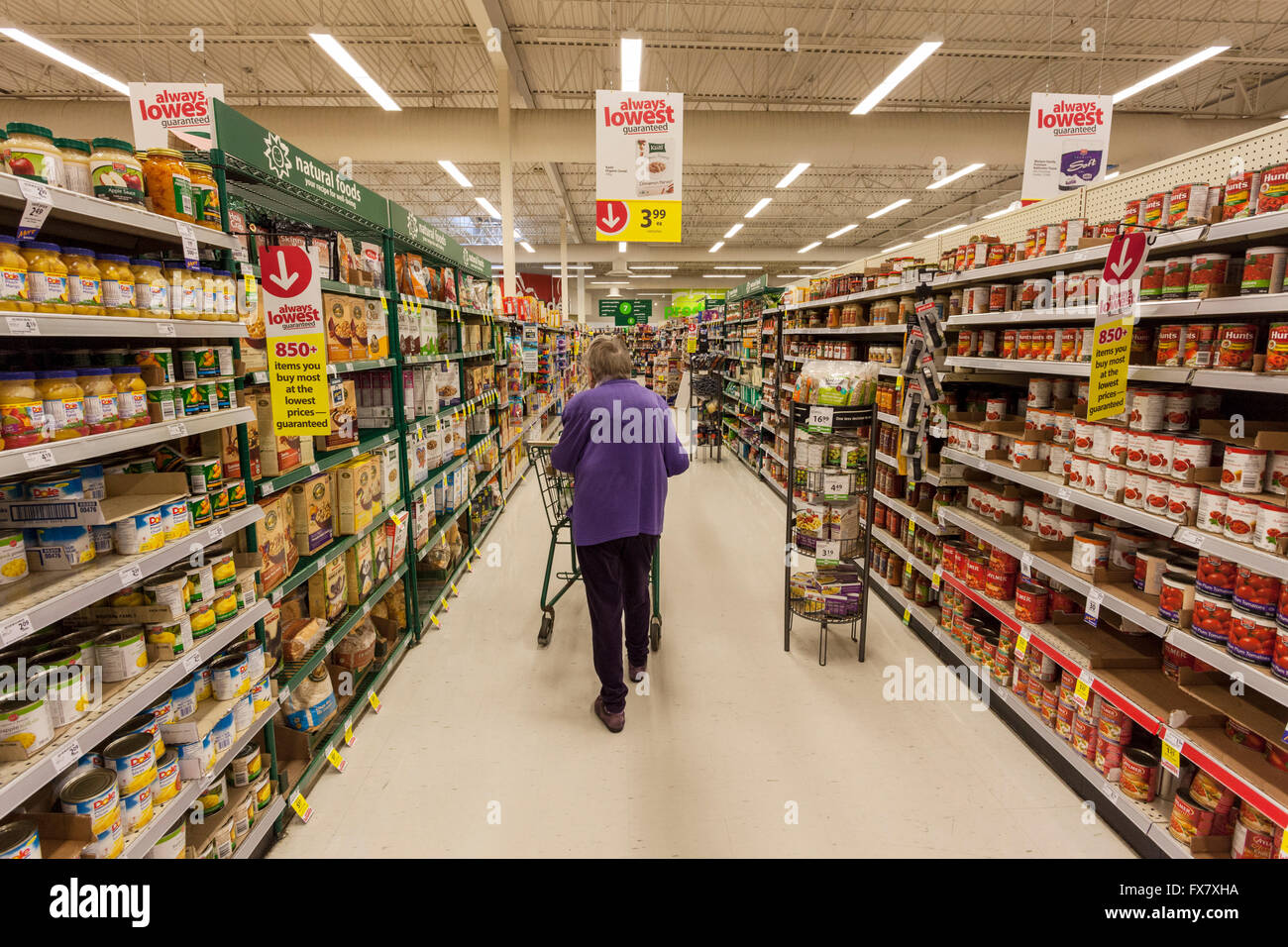 Femme âgée l'épicerie avec panier en magasin l'allée-Victoria, Colombie-Britannique, Canada. Banque D'Images