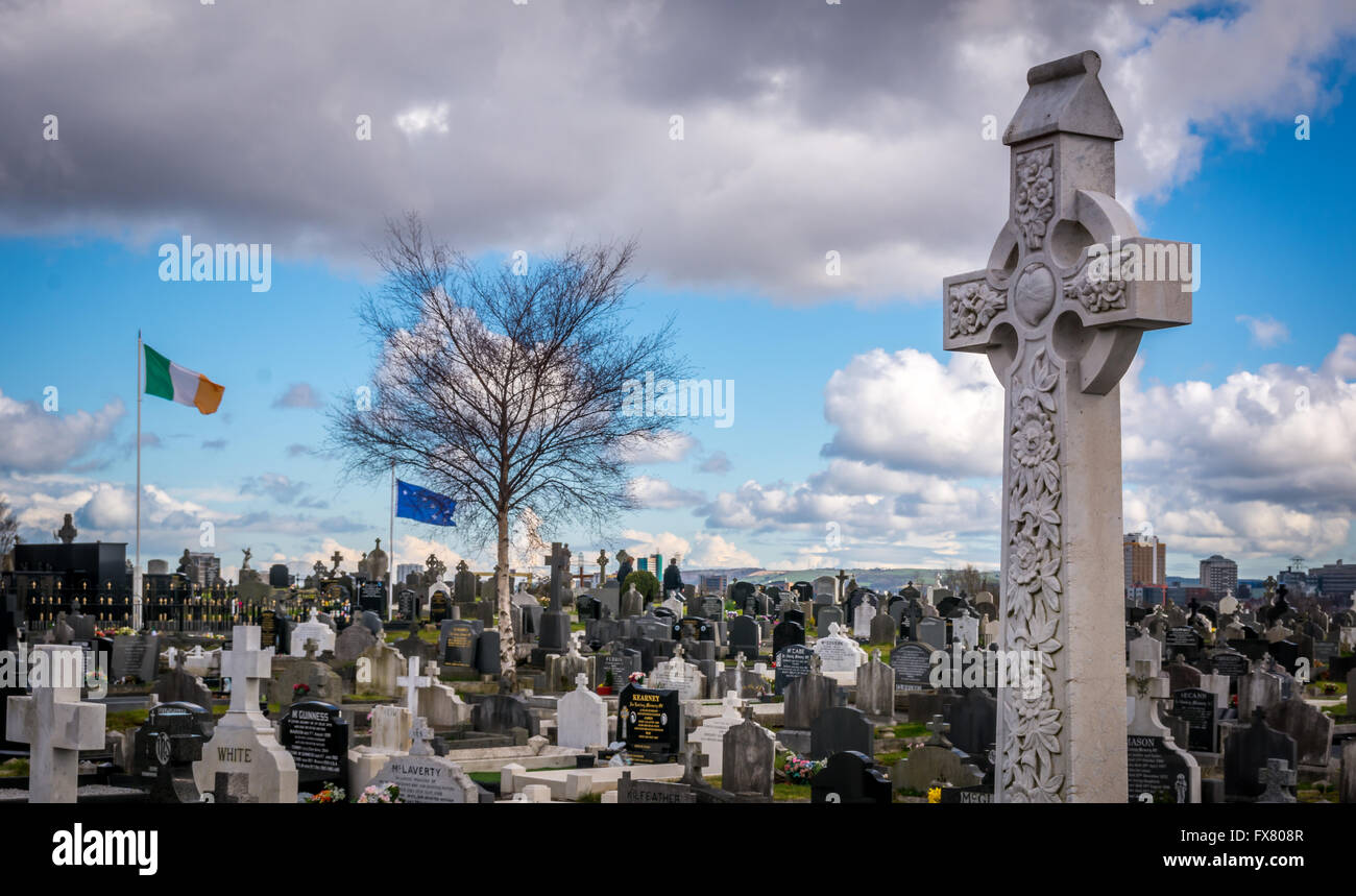 Le tricolore irlandais et Starry Plough voler en arrière-plan d'une croix celtique et tombes dans le cimetière de Milltown à Belfast. Banque D'Images