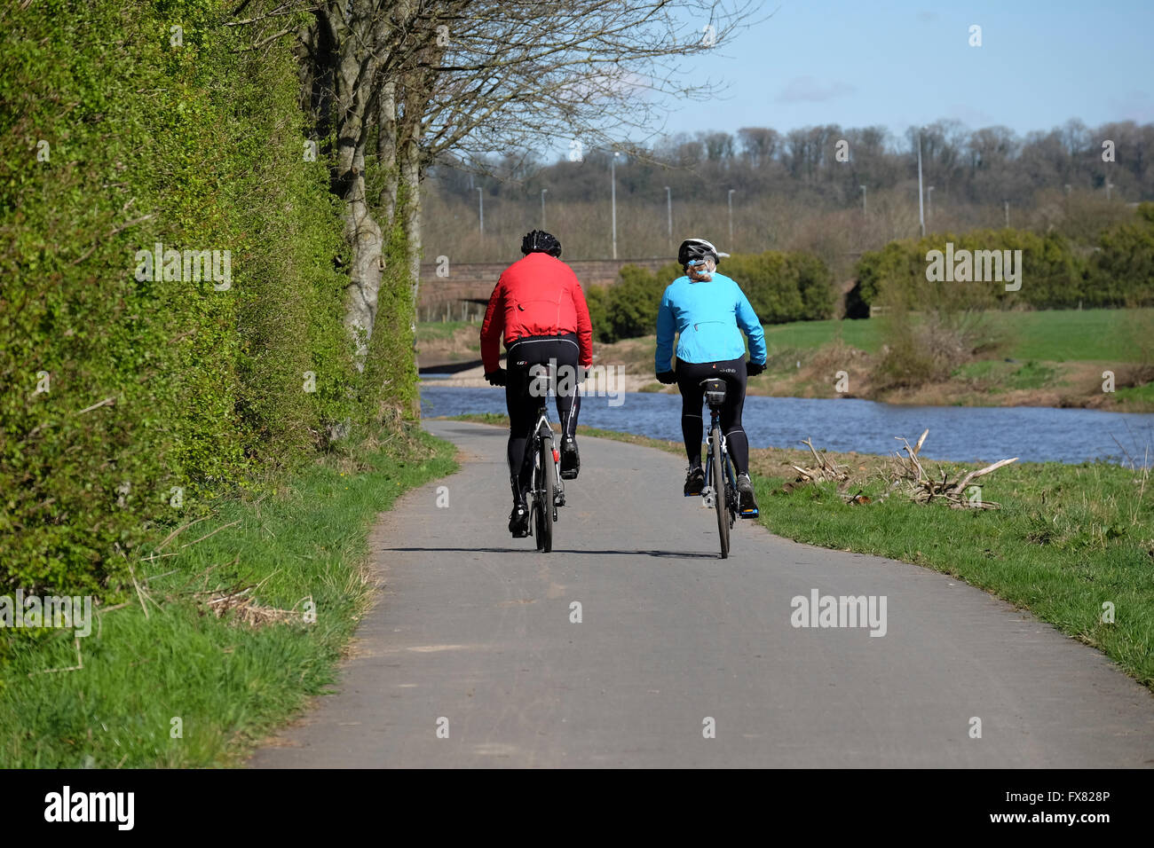 Un homme et les femmes ensemble à vélo le long d'un chemin près de la rivière Ribble dans le Lancashire Banque D'Images