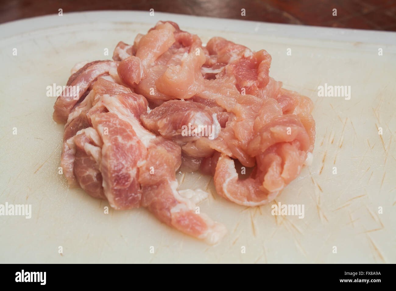 Tranches de porc sur le bloc de hachage en plastique Stock Photo Banque D'Images