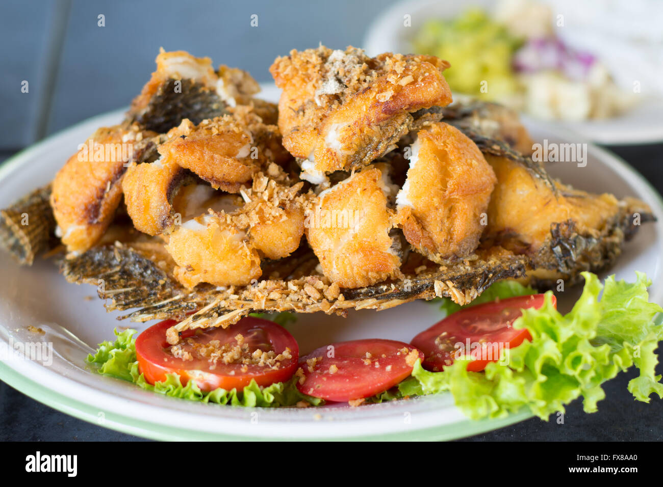 Délicieux poisson tilapia frit dans un plat Banque D'Images