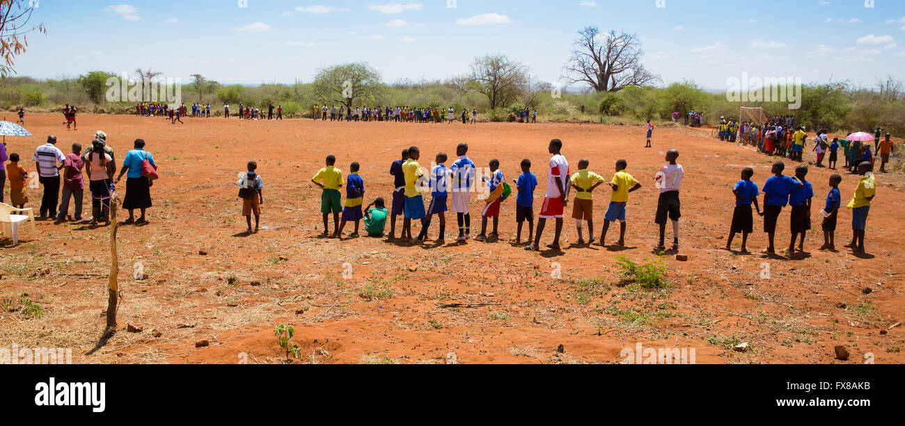 Les enfants de l'école pour le coup d'attente lors d'un match de football autour d'un emplacement près de vi dans le sud du Kenya Banque D'Images