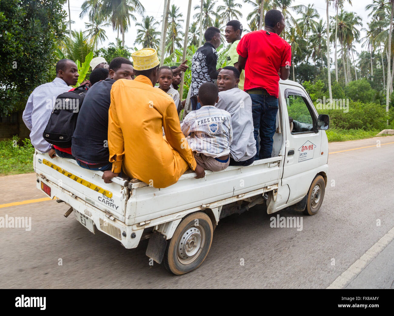 Petit camion surchargé transportant au moins 14 personnes sur une route très fréquentée en Afrique de l'Est de Zanzibar Banque D'Images
