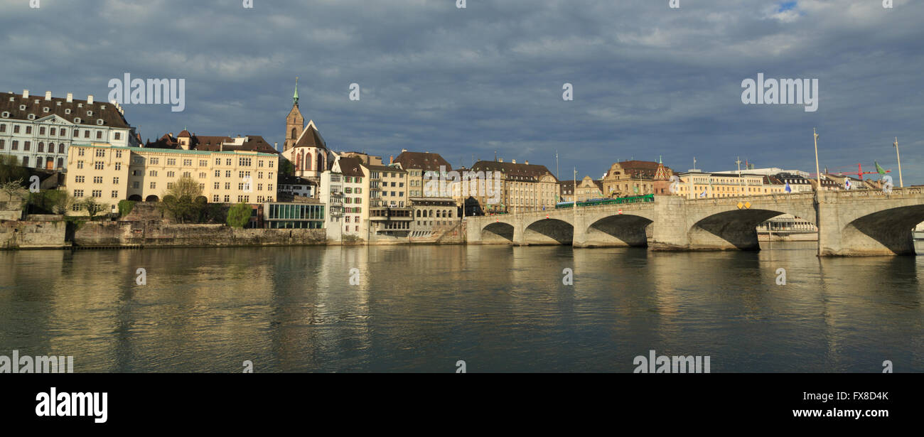 Une photographie panoramique d'un tramway traversant le pont moyen historique (Mittlerebrücke) à Bâle, Suisse. Banque D'Images