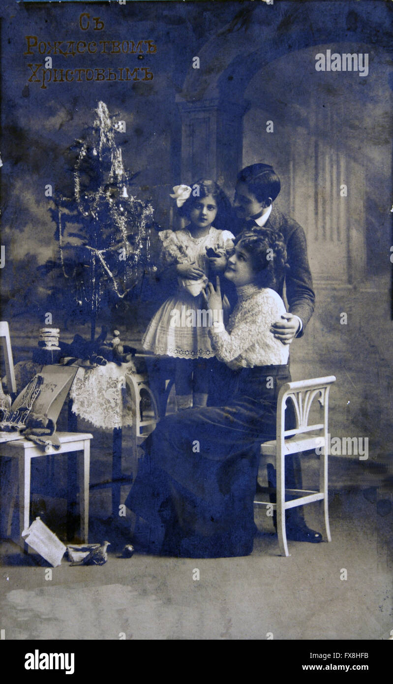 Russie - circa 1908 : carte postale imprimée en Russie montre aux parents avec enfants près de l'arbre de Noël Banque D'Images