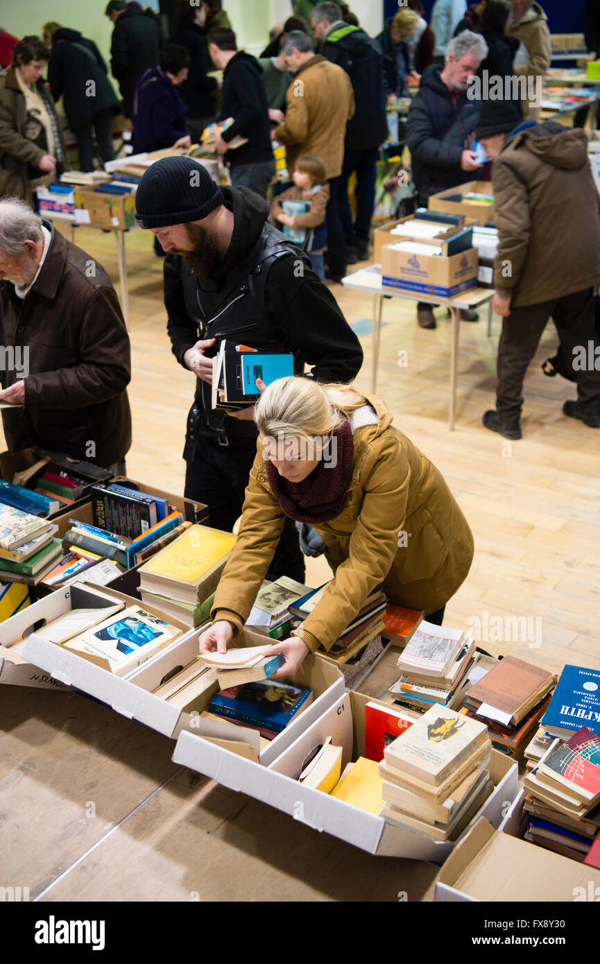 Personnes saisissant des brassées de second hand book affaires au l'Ystwyth Books shop vente de stocks excédentaires, le Pays de Galles UK Banque D'Images