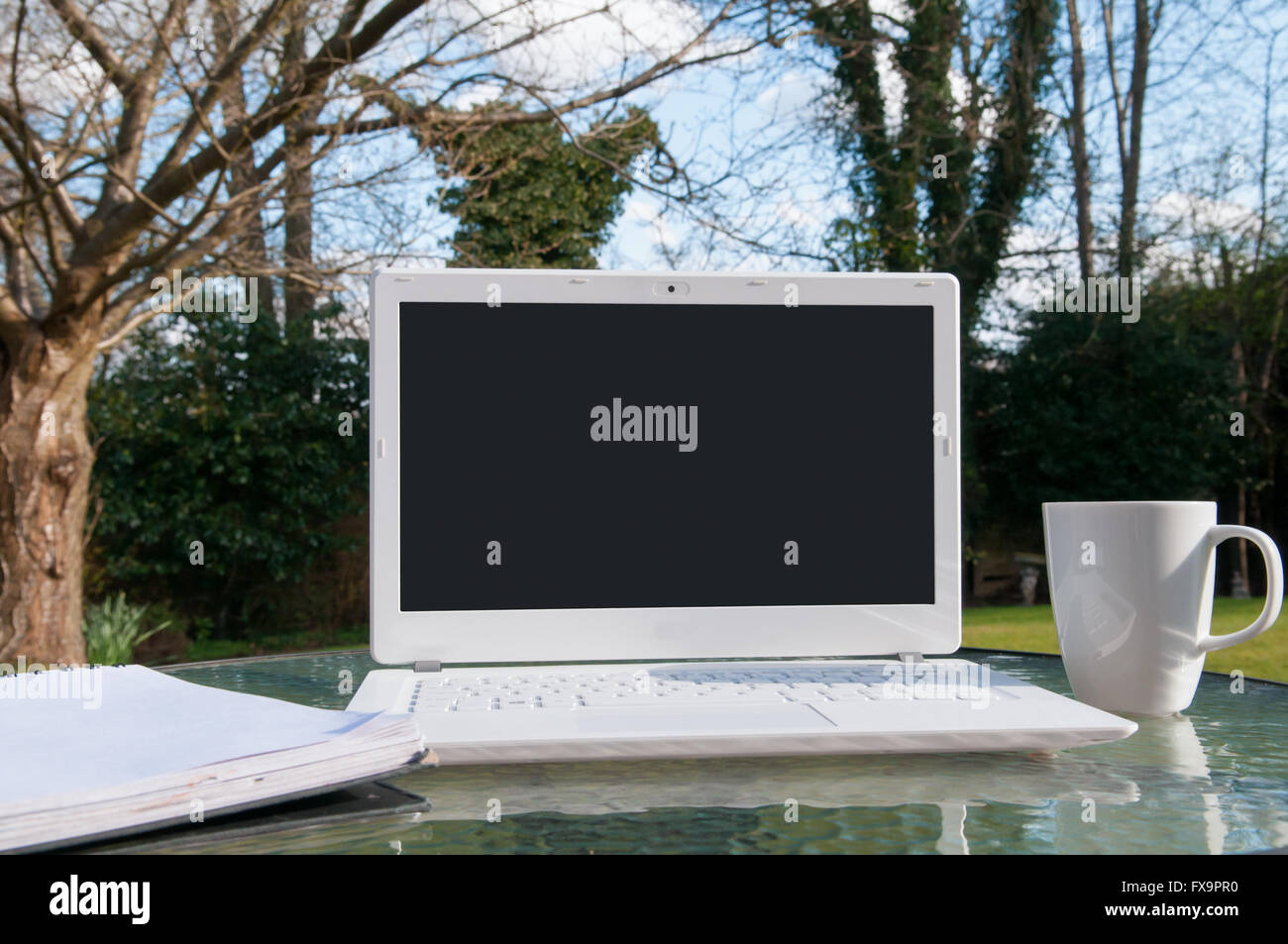 Les ordinateurs portables avec un écran blanc à l'extérieur par une journée ensoleillée Banque D'Images