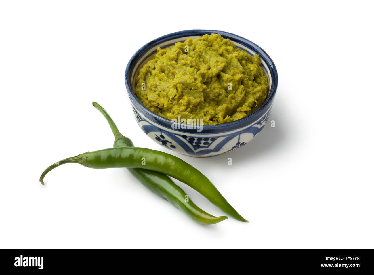 Bol avec harissa Marocain vert et piment vert frais sur fond blanc Banque D'Images