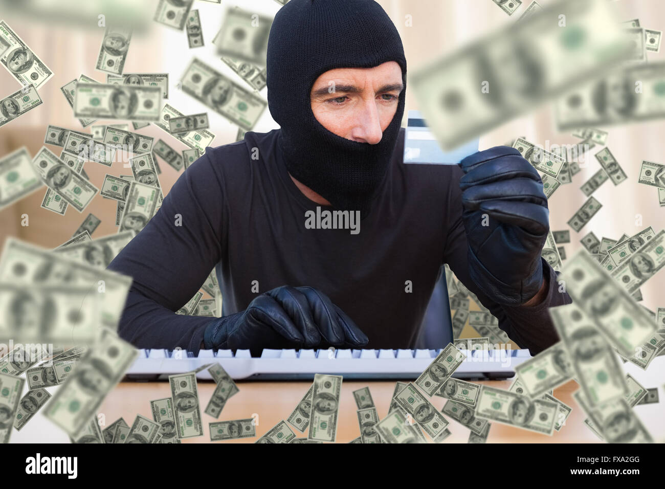 Image composite de cambrioleur avec balaclava hacking un ordinateur portable Banque D'Images