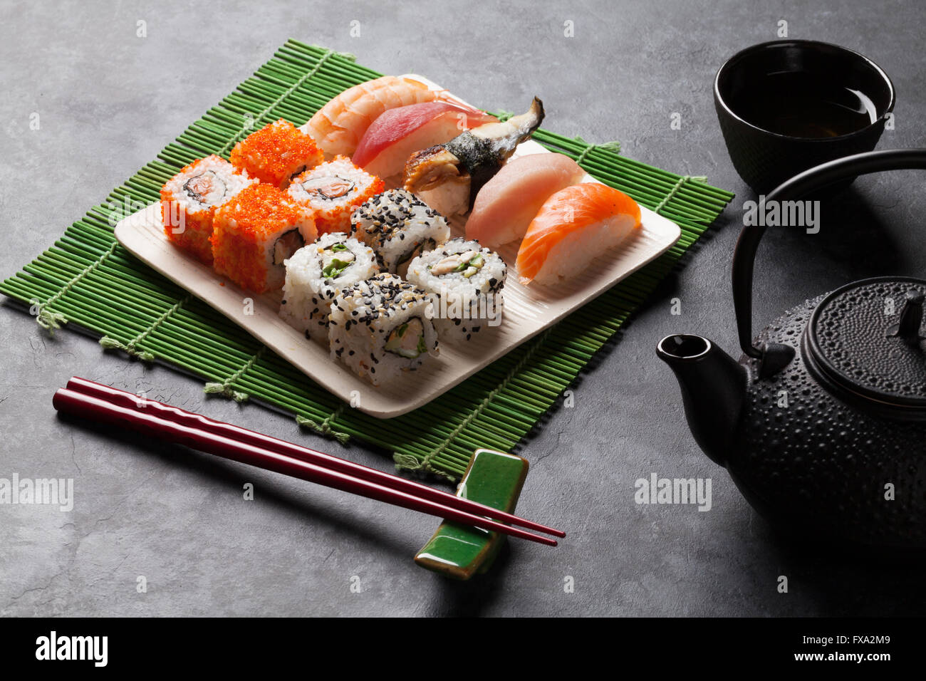 Ensemble de sushi et maki rouleau et le thé vert plus de table en pierre Banque D'Images