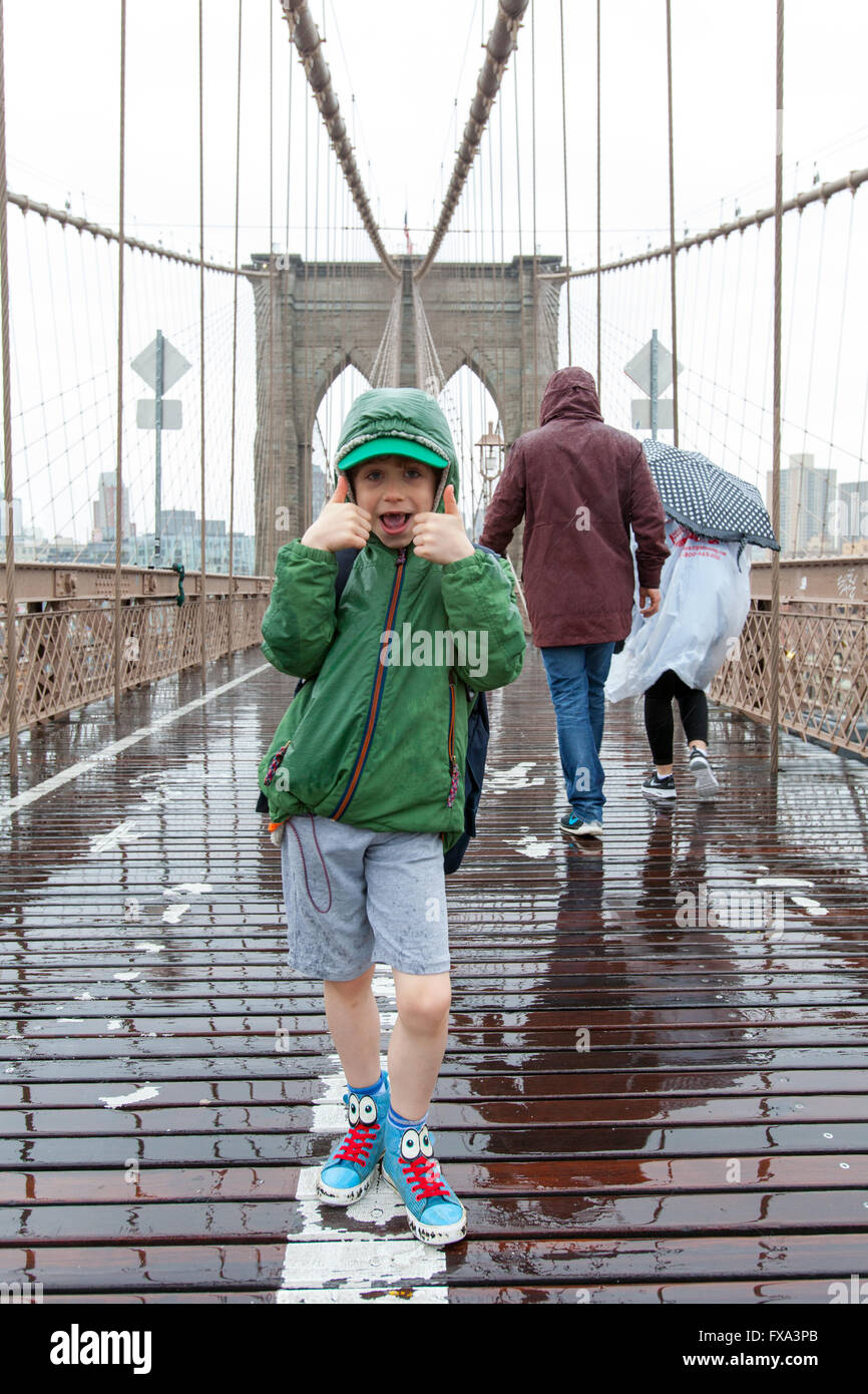 Un garçon de six ans sur le pont de Brooklyn à la pluie, New York City, États-Unis d'Amérique. Banque D'Images