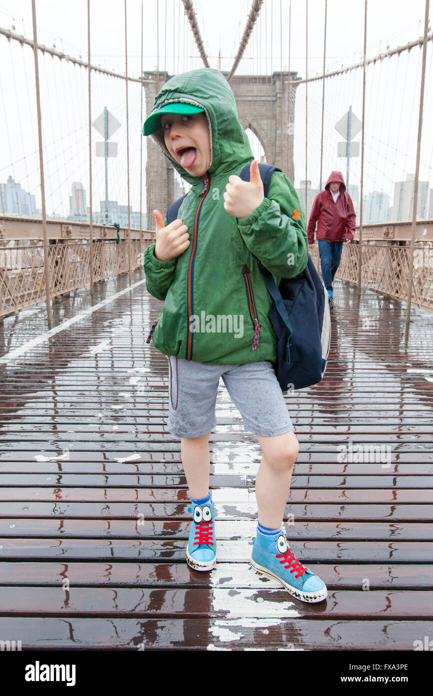 Un garçon de six ans sur le pont de Brooklyn à la pluie, New York City, États-Unis d'Amérique. Banque D'Images