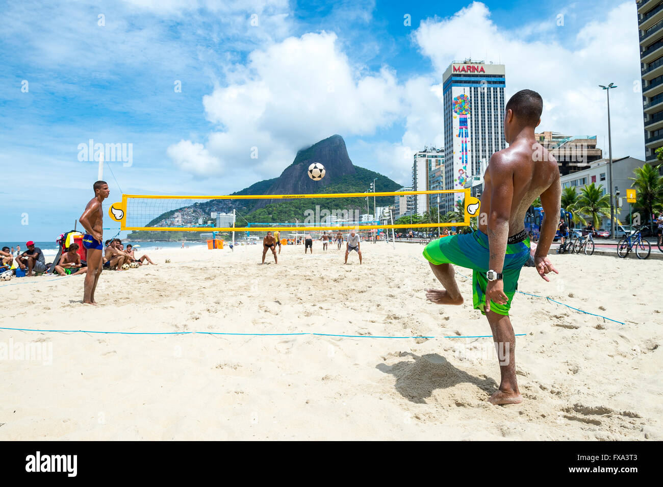 RIO DE JANEIRO - le 17 mars 2016 : jeunes hommes jouent un jeu de footvolley, un sport qui combine le football et volley-ball. Banque D'Images
