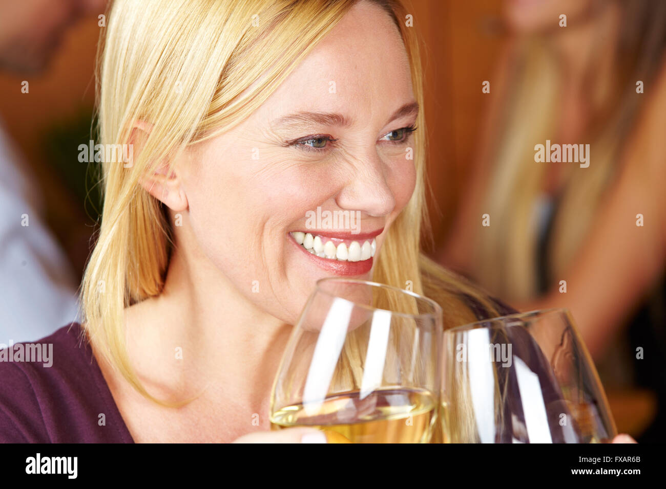 Smiling senior woman with white wine in a restaurant Banque D'Images