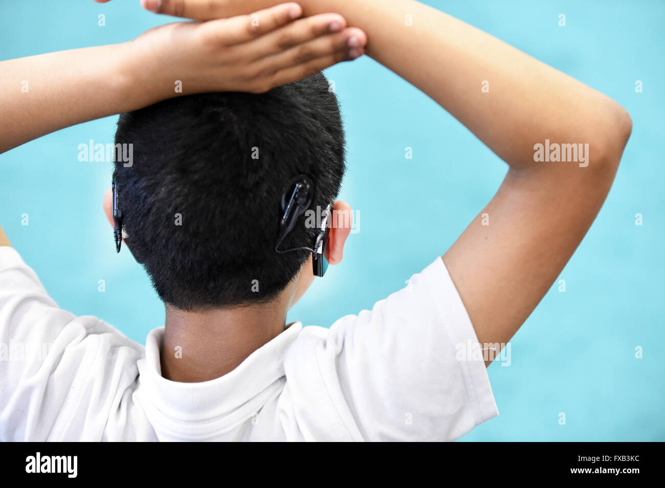 Un garçon portant des appareils auditifs aux deux oreilles UK Banque D'Images