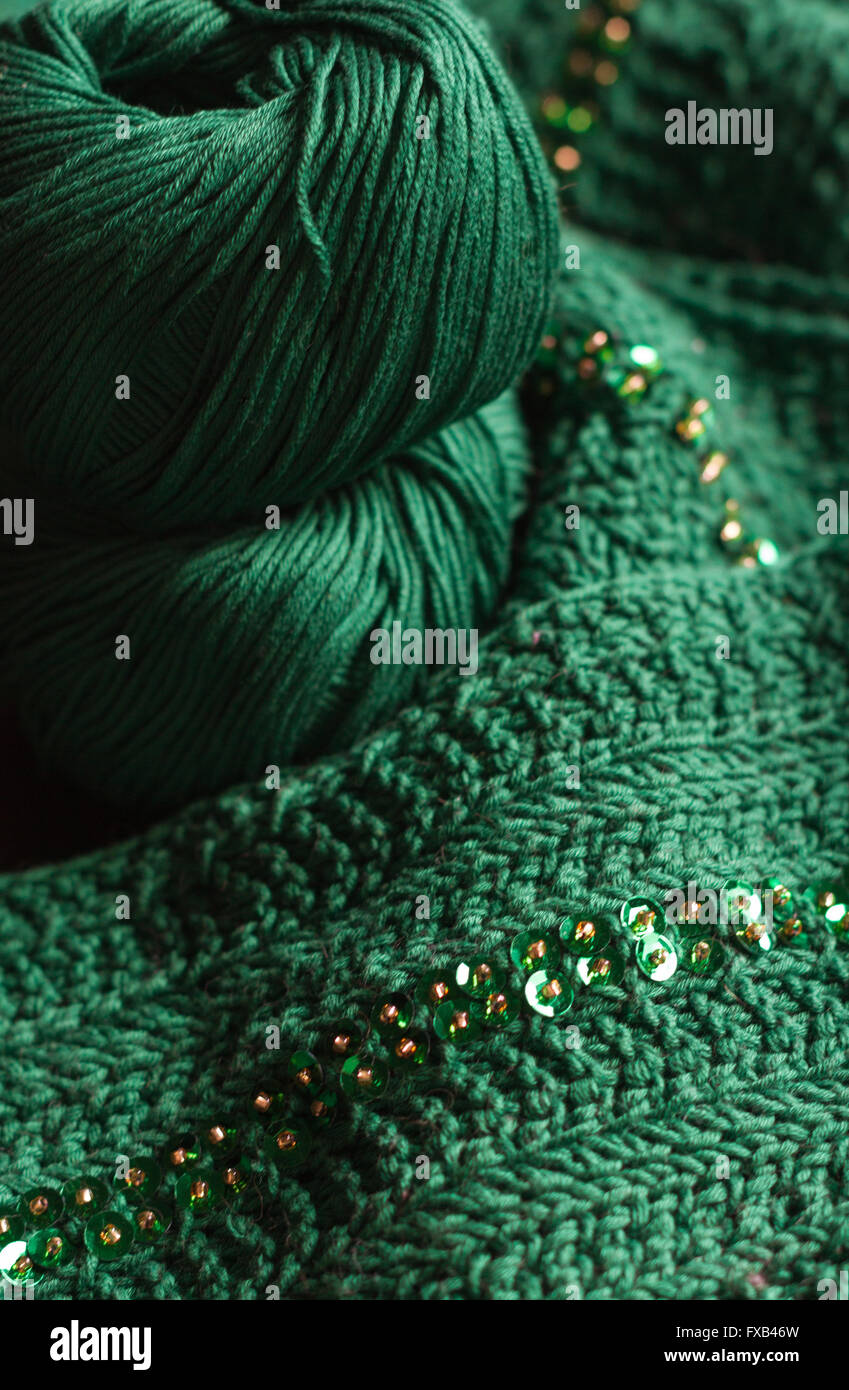 Deux balles de laine vert et vert foulard perlé. Le fil est d'un vert profond. Perles sont l'or et brillants. Banque D'Images