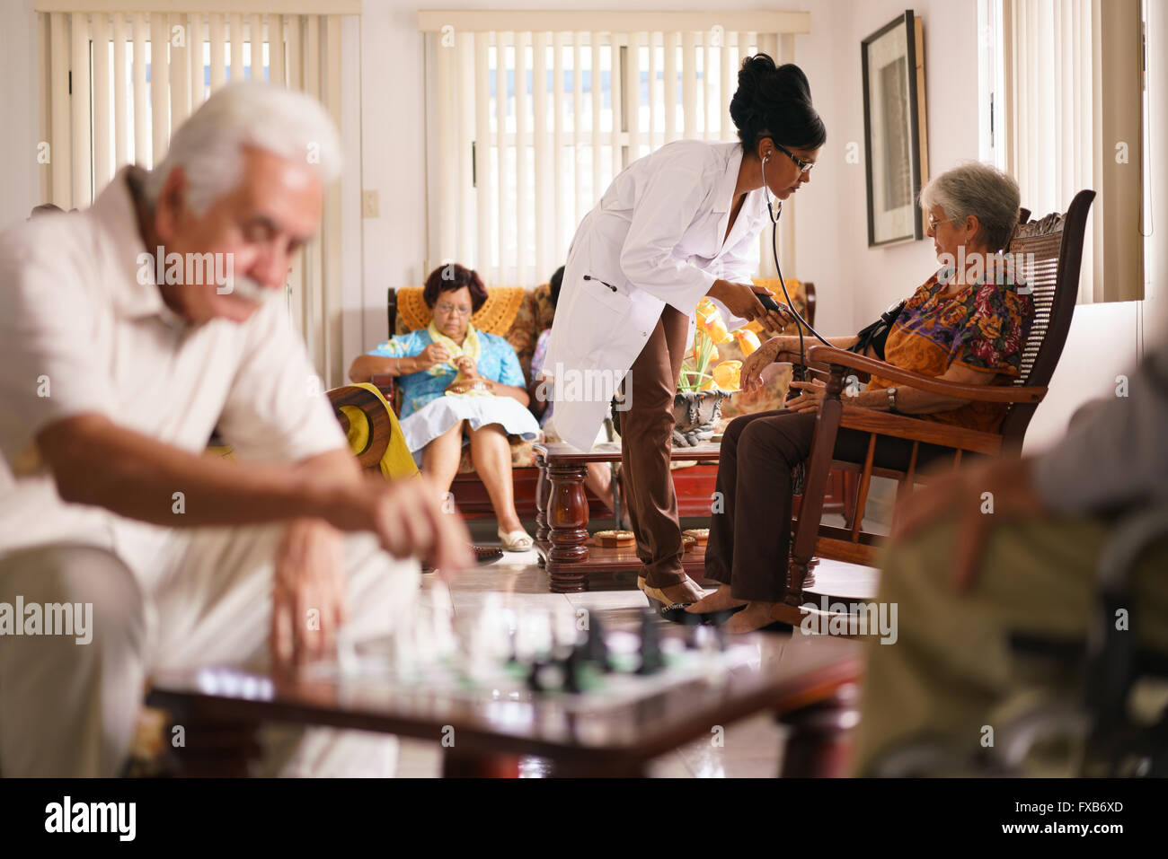 Les personnes âgées dans les soins gériatriques : visite d'un patient âgé, la mesure de la pression artérielle d'un senior femme. Groupe de ret Banque D'Images Les personnes âgées dans les soins gériatriques : visite d'un patient âgé, la mesure de la pression artérielle d'un senior femme. Groupe de ret Banque D'Images