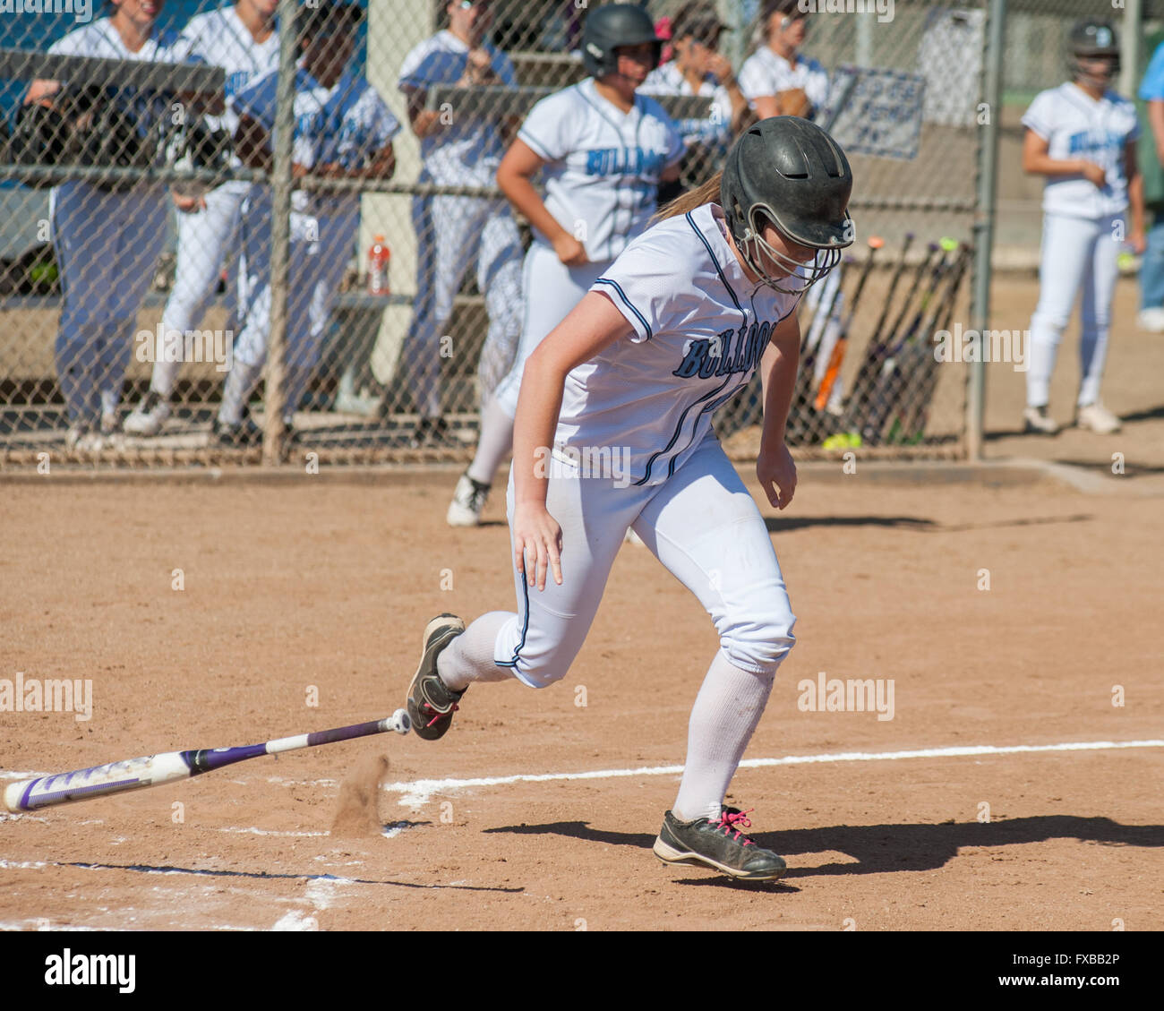 En softball uniforme blanc l'abandon de la bat et d'exécution. Banque D'Images