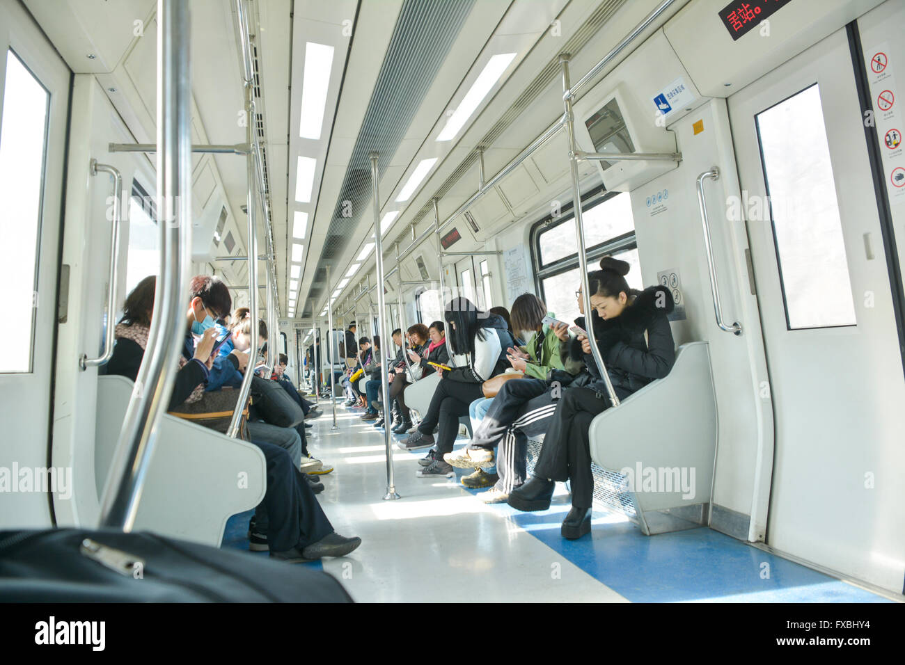 Le peuple chinois using mobile phone on Subway train léger Banque D'Images