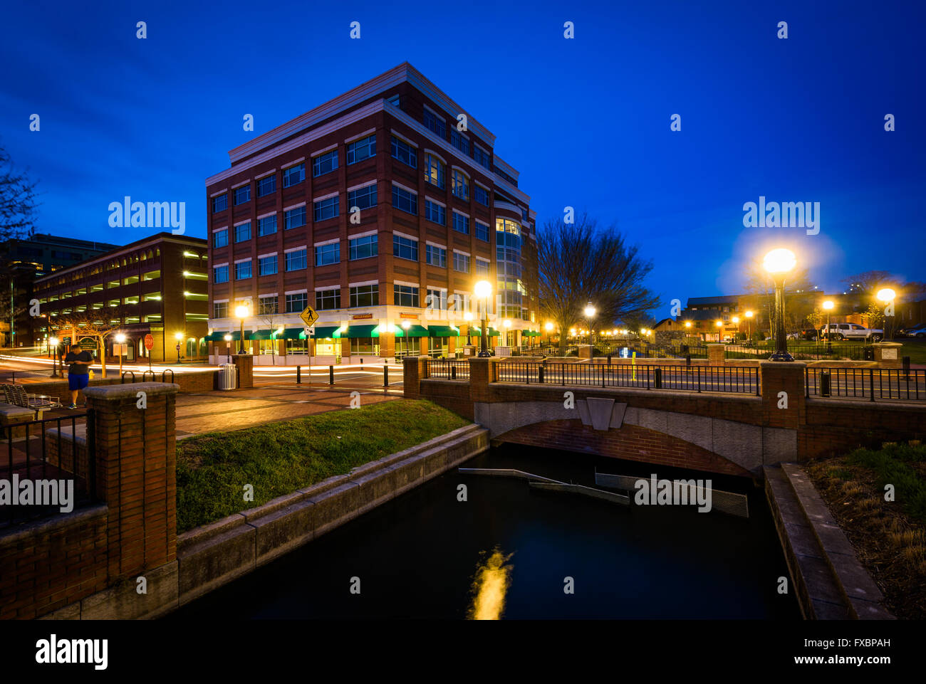 Bâtiment moderne et pont sur le ruisseau Carroll dans la nuit, à Carroll Creek Parc linéaire, de Frederick, Maryland. Banque D'Images