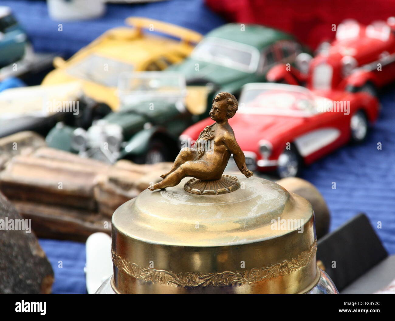 Petit vintage en laiton la figure d'un enfant à l'avant-plan avec des petites voitures, marché aux puces, l'Allemagne. Banque D'Images