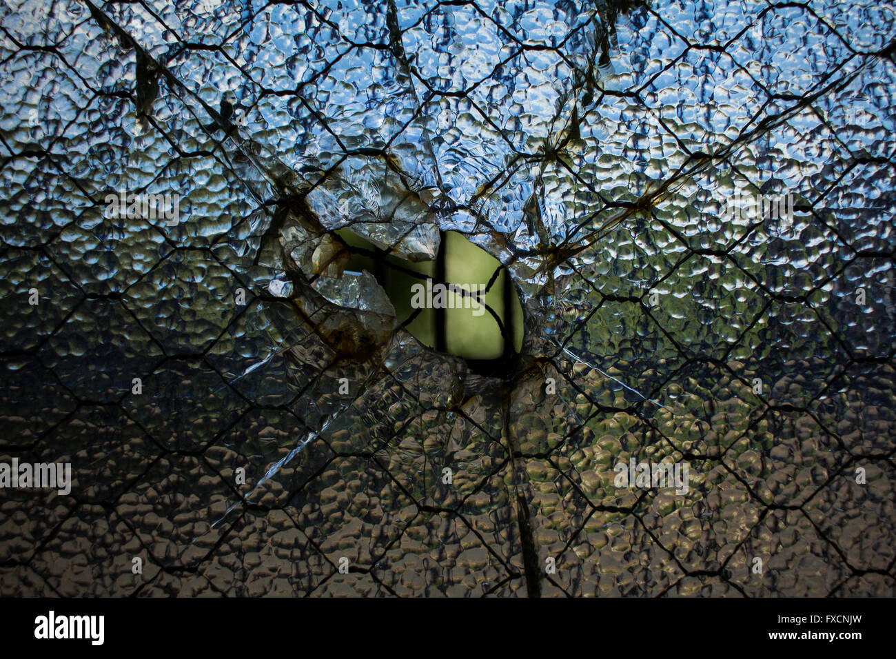 Une fenêtre fissurée avec un trou au milieu. Banque D'Images