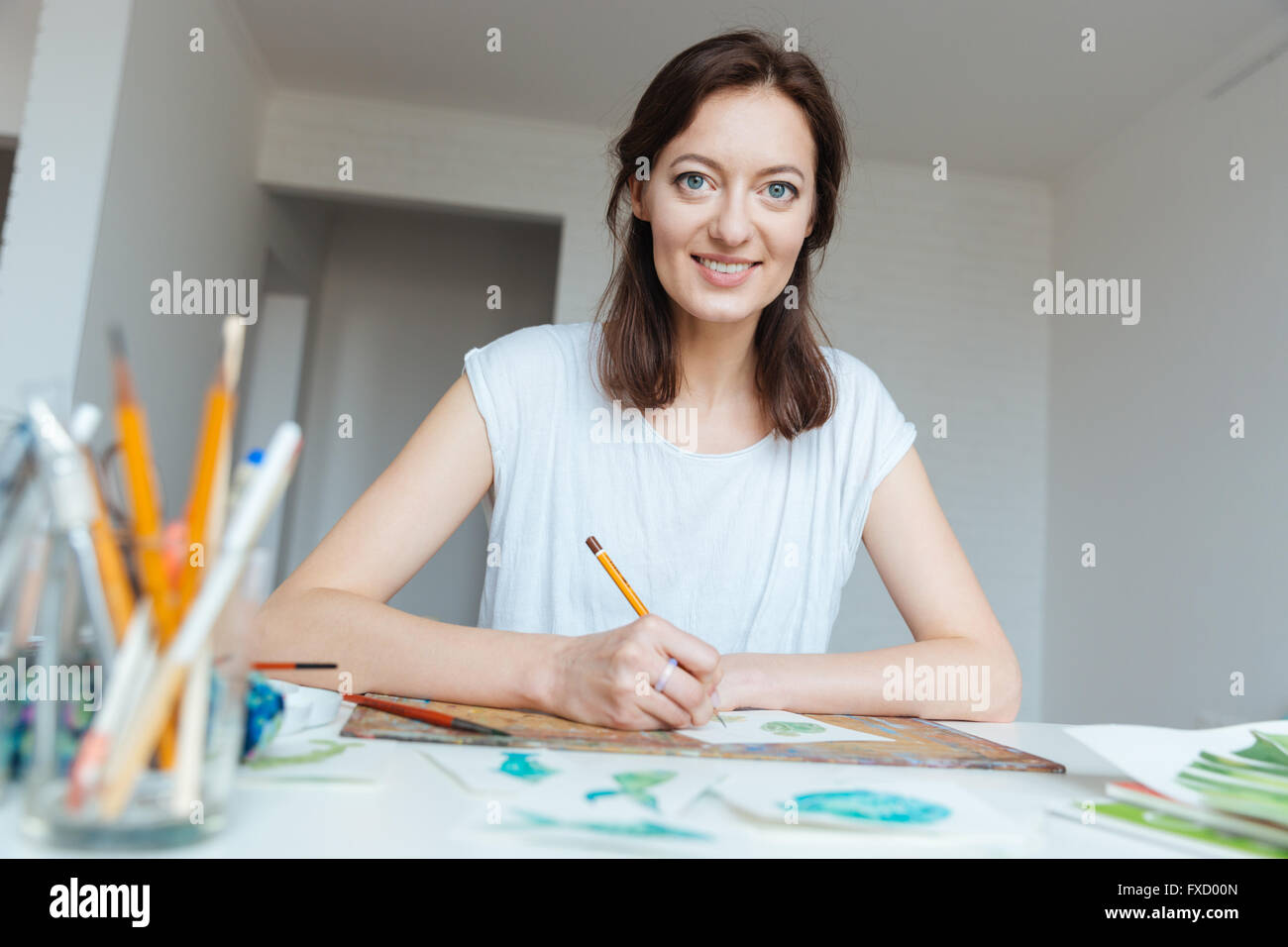 Portrait of happy belle femme artiste dessin de crayon à la table dans la classe d'art Banque D'Images