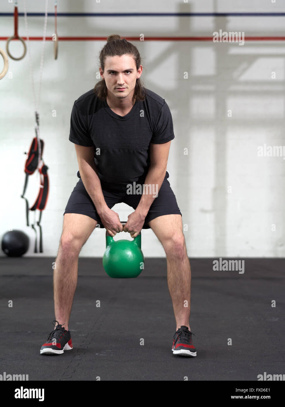 Photo d'un jeune homme l'entraînement avec un électrique bell dans une salle de sport. Banque D'Images