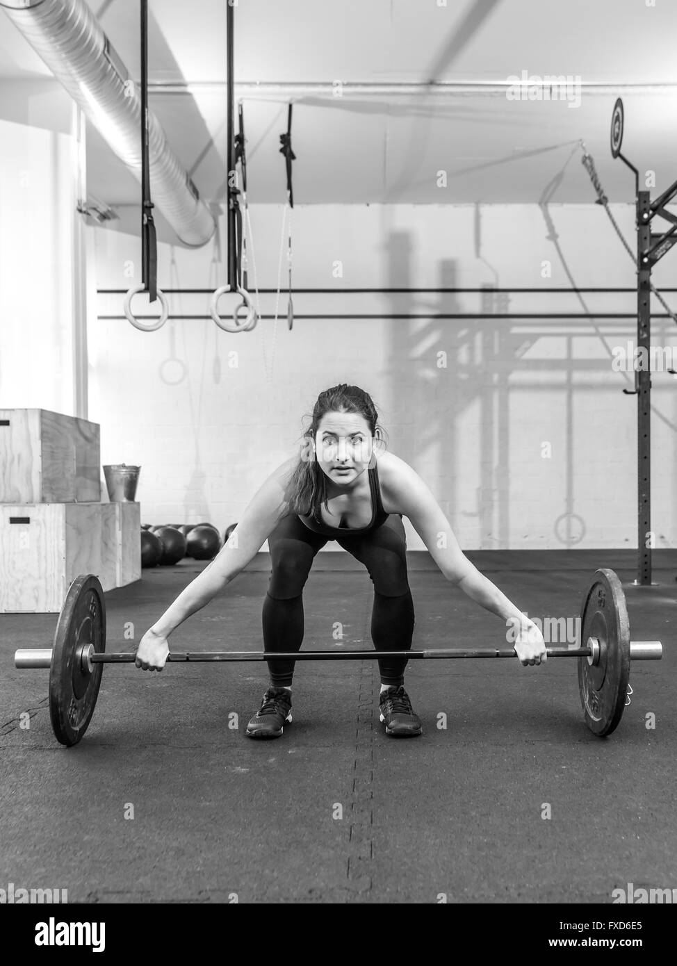 Photo d'une jeune femme à un sport crossfit soulevant un barbell. Banque D'Images