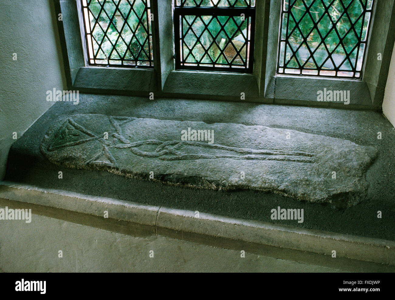 Pre-Conquest ou plus tard contre la dalle construite dans un rebord de fenêtre à l'intérieur de l'église, Pembrokeshire Nevern : Latin tressé croix faite de 2 cordons ou rubans. Banque D'Images