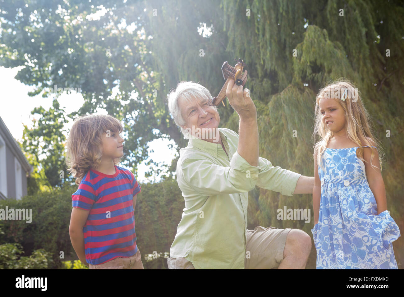 Grand-père ludique de jouer avec leurs petits-enfants à la cour Banque D'Images