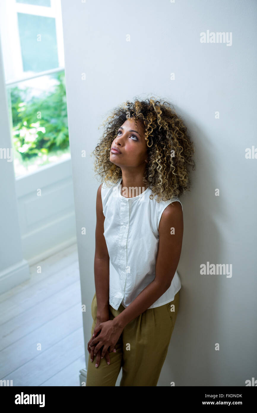 Tendu woman leaning on wall Banque D'Images