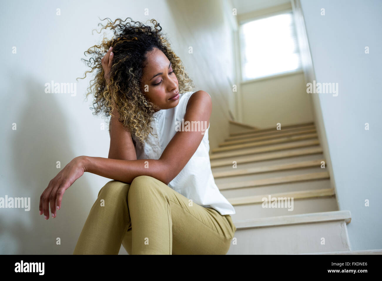 Femme assise tendue dans les escaliers Banque D'Images