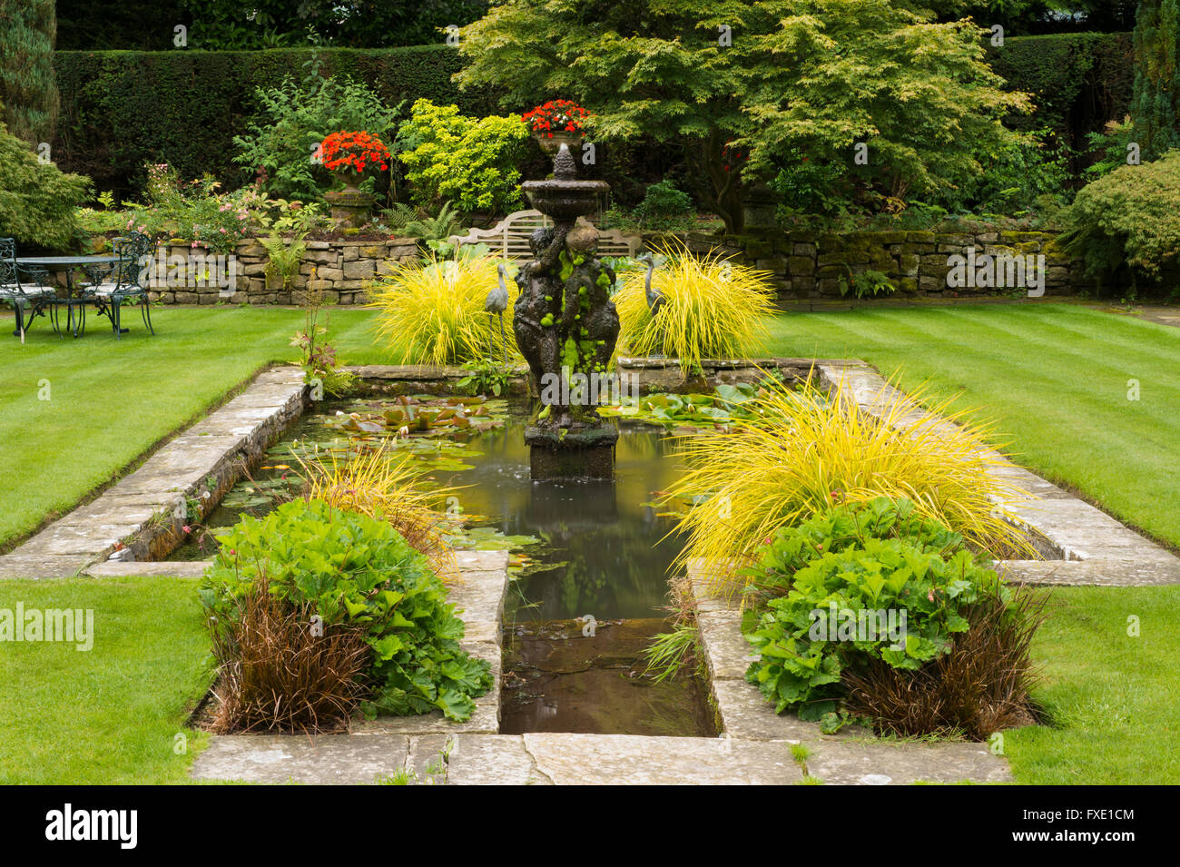 Une belle salle, traditionnelle, paysagée, country garden, West Yorkshire, Angleterre - bassin d'agrément, fontaine, coin salon et bar d'pelouse. Banque D'Images