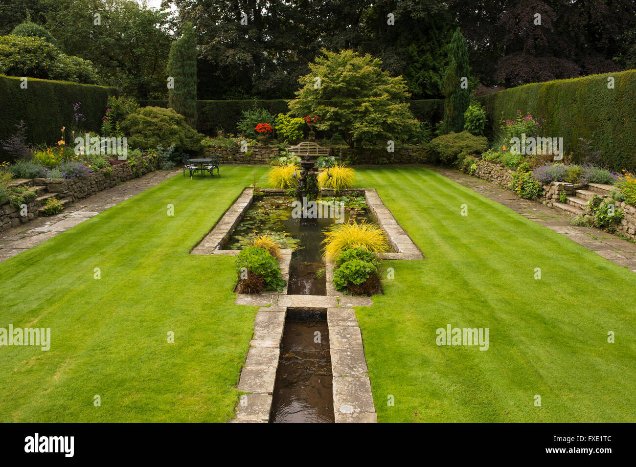 Une belle salle, traditionnelle, paysagée, country garden, West Yorkshire, Angleterre - bassin d'agrément, fontaine, coin salon et bar d'pelouse. Banque D'Images