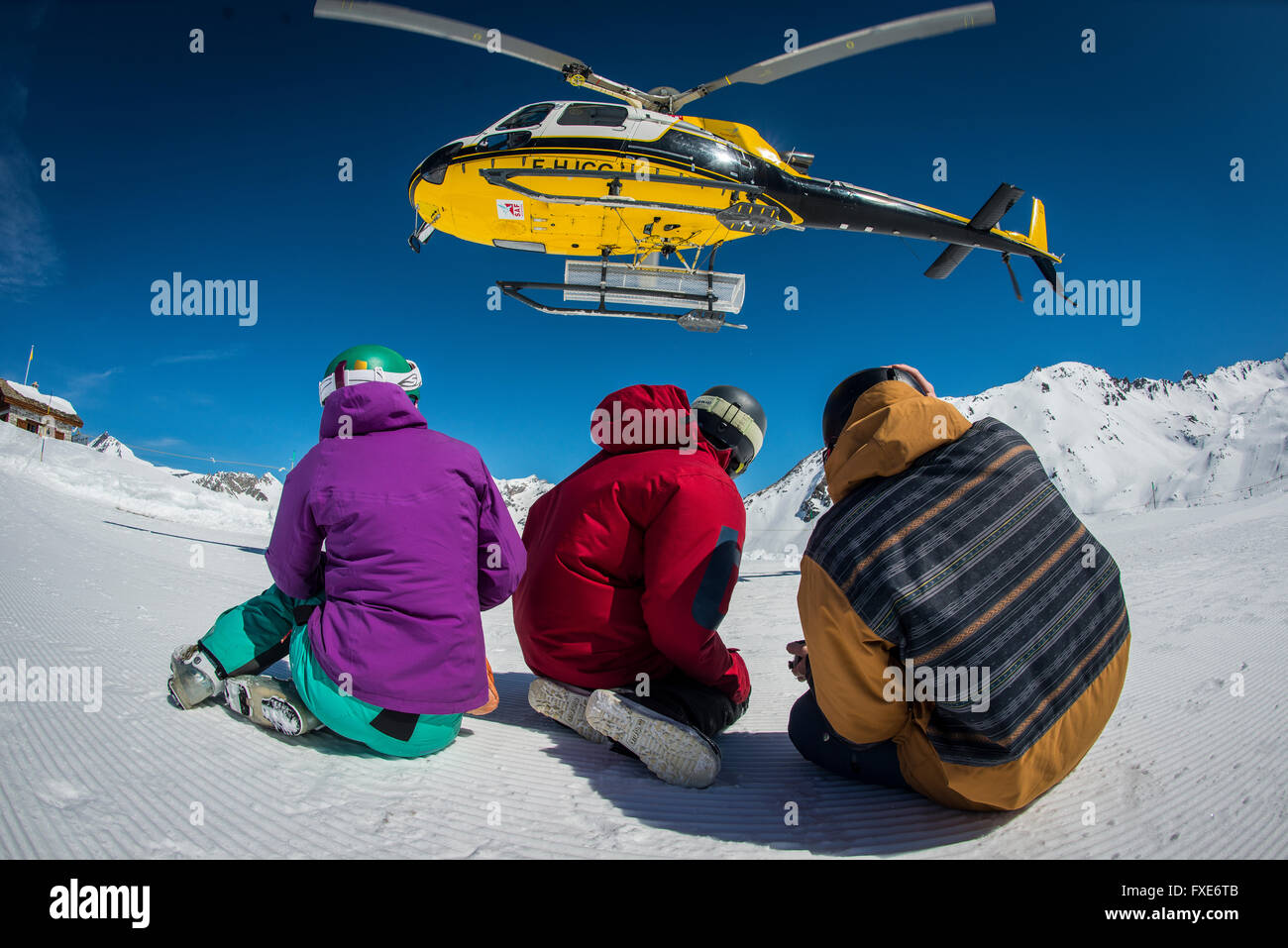 Un groupe de skieurs et snowboarders sont déposés par hélicoptère au sommet d'une montagne dans les Alpes françaises. Banque D'Images