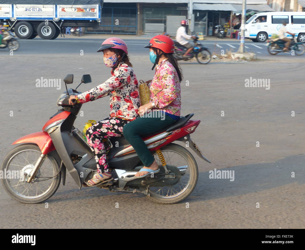 Vietnam, deux femmes portant des masques chirurgicaux en scooter Banque D'Images