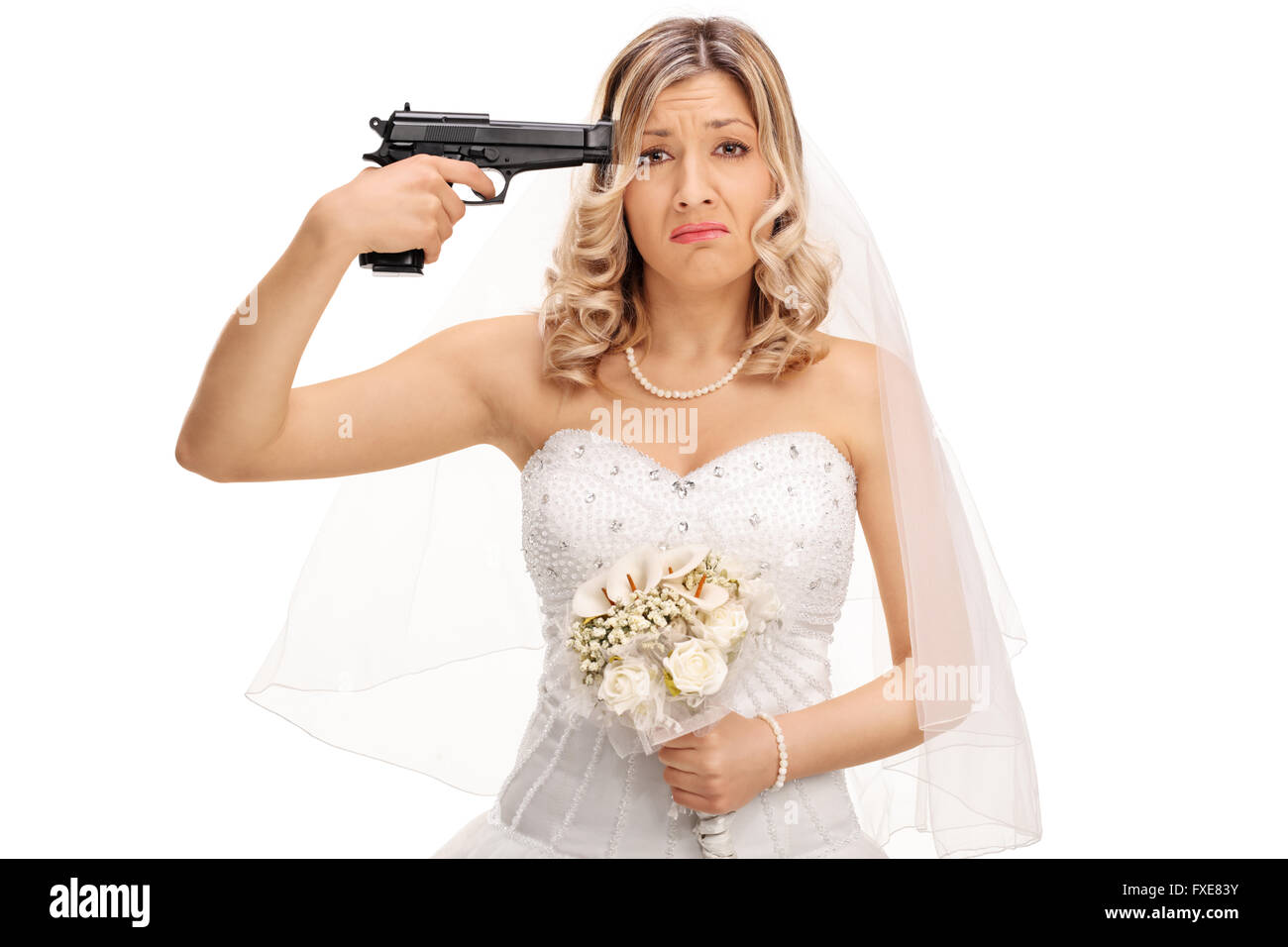 Jeune mariée désespérée tenant un pistolet contre sa tête et regardant la caméra isolé sur fond blanc Banque D'Images
