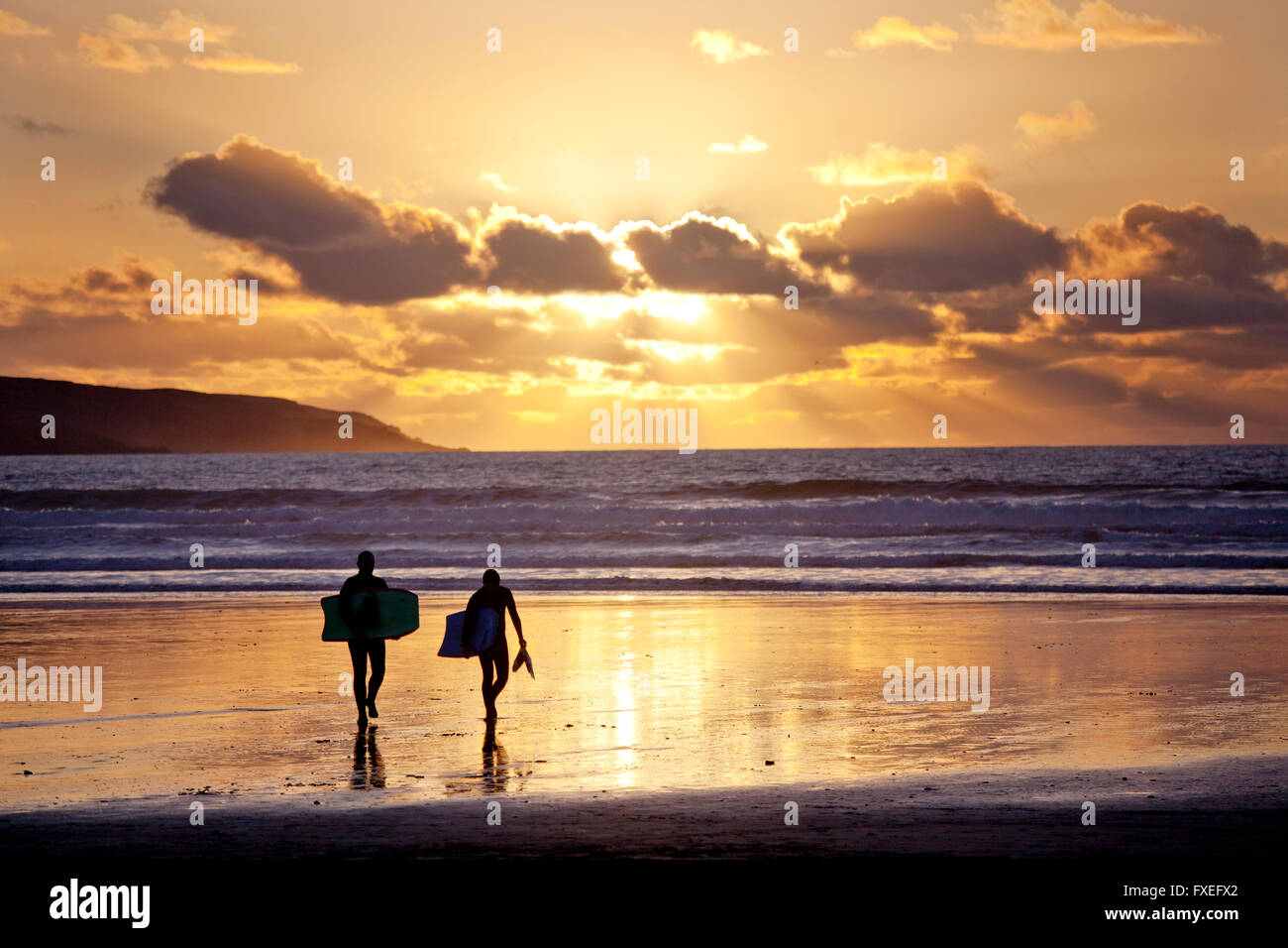 Deux pensionnaires du corps au coucher du soleil sur la plage de Gwithian Cornwall, UK Banque D'Images