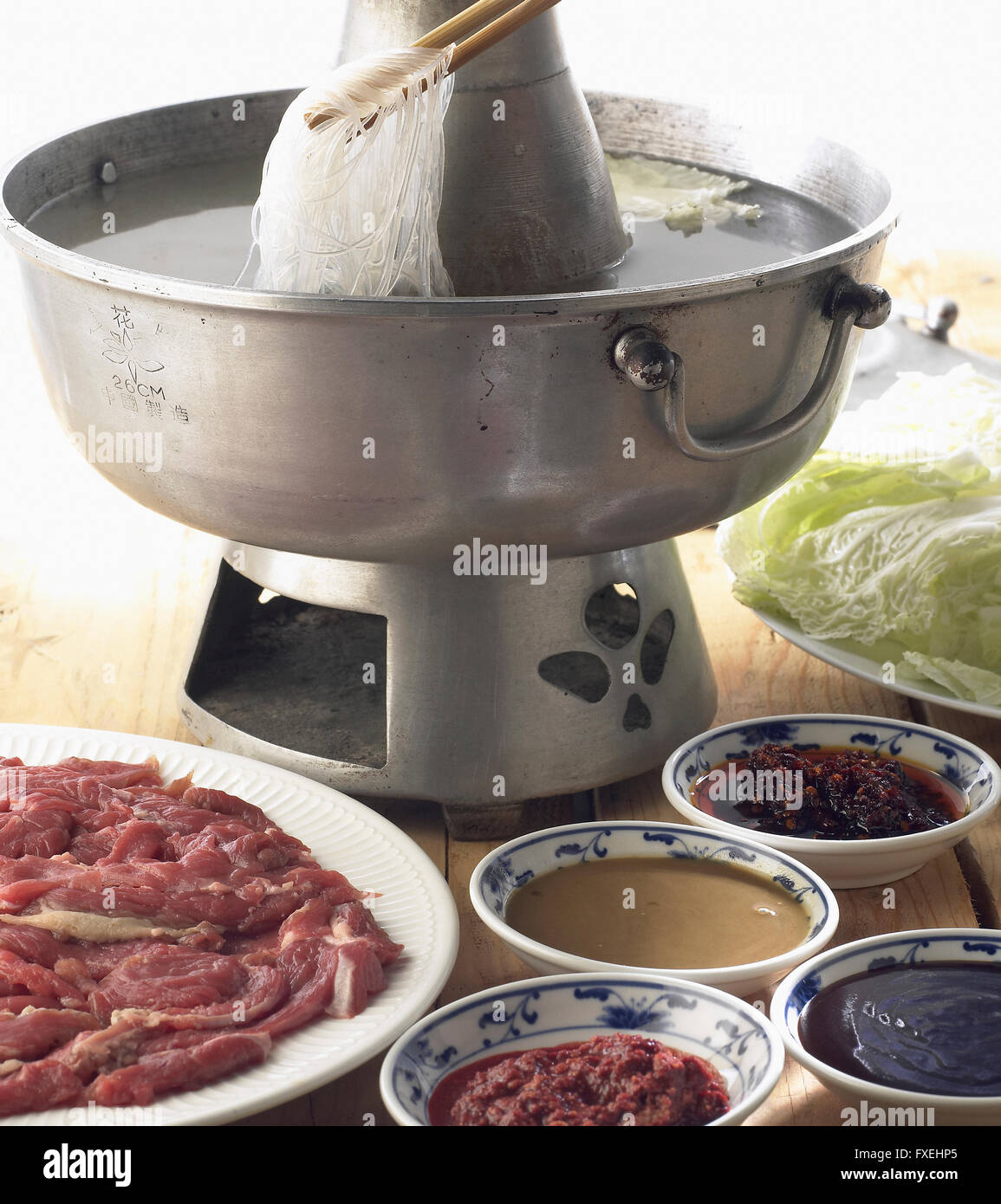 Mongolian hotpot, émincé d'agneau, les légumes et les nouilles dans l'eau bouillante, servi avec choix de sauces Banque D'Images