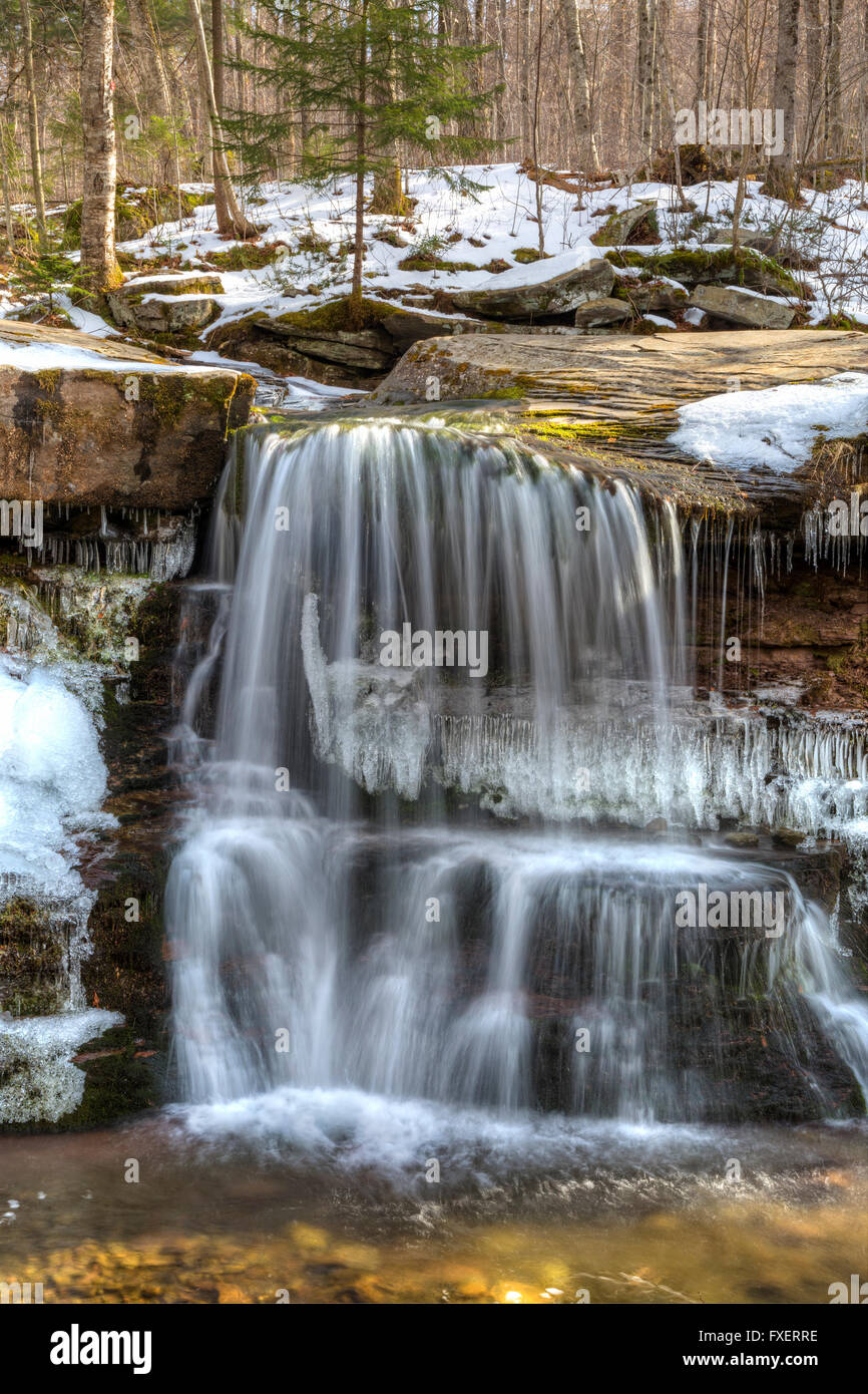 L'eau tombe doucement dans un bassin partiellement gelé plus de tuer de l'Ouest tombe dans les Catskills Mountains of New York. Banque D'Images