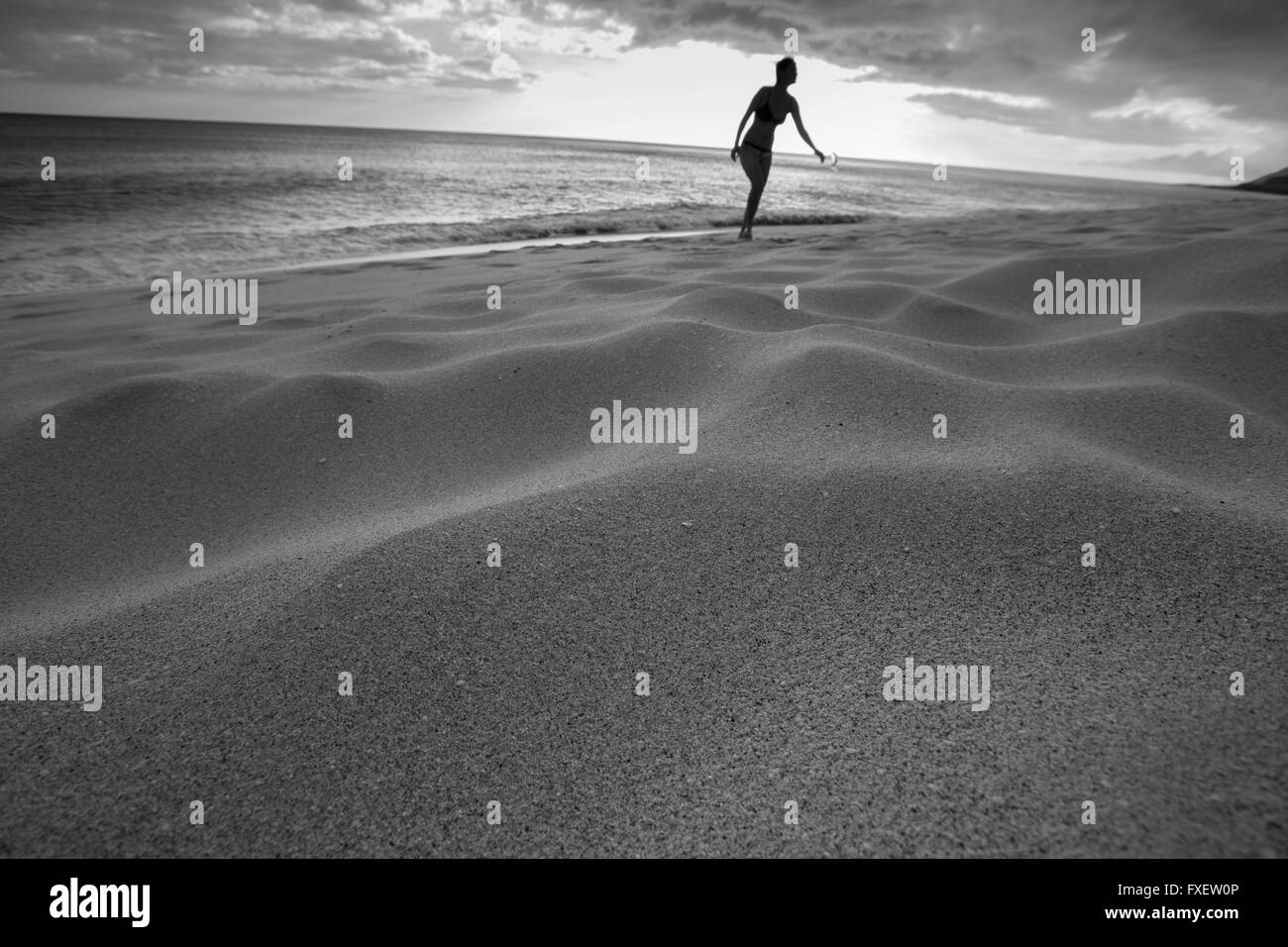 Young woman stretching et jouer à la rive, Keawaula Beach, West Oahu, Hawaii Banque D'Images