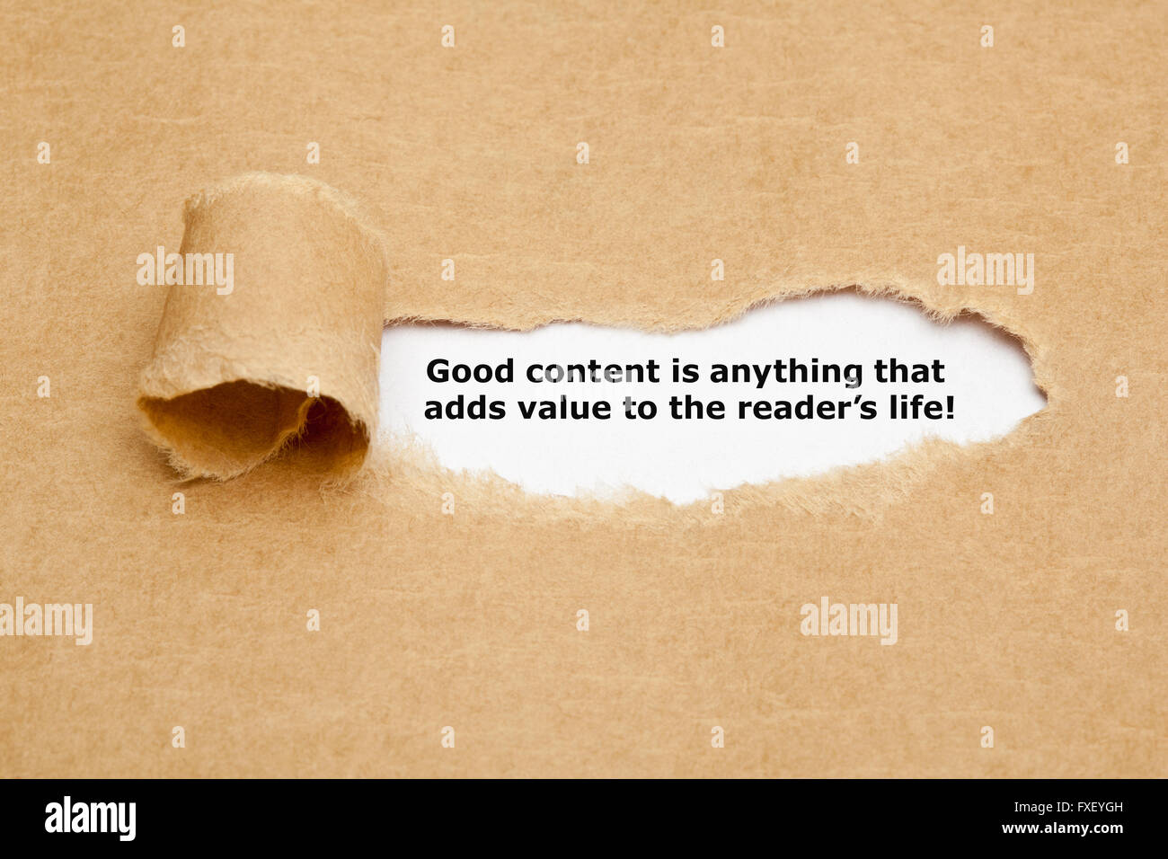 Le devis du bon contenu, c'est tout ce qui ajoute de la valeur aux lecteurs la vie, apparaître derrière déchiré papier brun. Banque D'Images