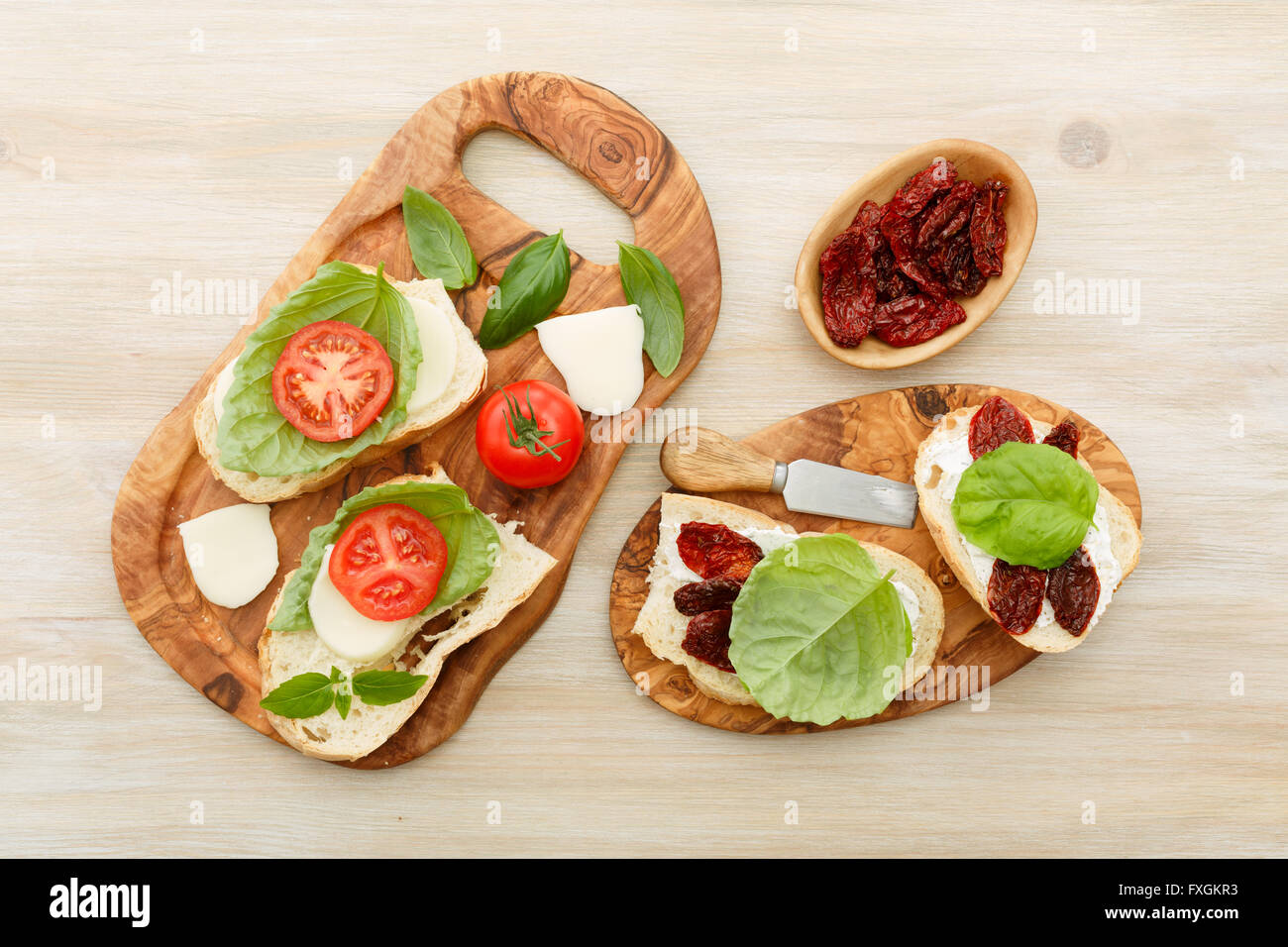 Des sandwichs ouverts de ciabatta, des tomates séchées, de la crème de fromage et de basilic feuille de laitue. Antipasti Banque D'Images