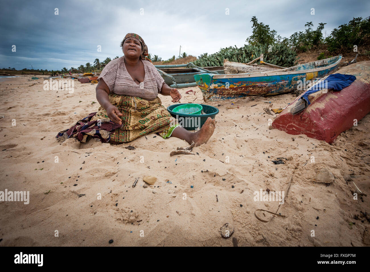 Le Mozambique, l'Afrique, une femme sur la plage est la cuisson, sable blanc, ciel nuageux. Banque D'Images